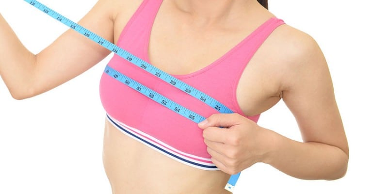 fit woman measuring breast