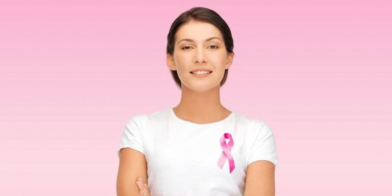 Woman with a pink ribbon pinned to chest